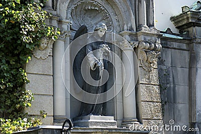 Sculpture of an Angel with flowers roses in her hand on a family tomb / crypt at the cemetery at Suedstern Stock Photo
