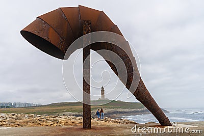 Sculpture of the Caracola and in the background the Tower of Hercules in the city of A Coruna in Galicia, Spain Editorial Stock Photo