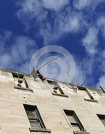 A sculpture of a fisherman installed on the top of the tall building in Oamaru, New Zealand Editorial Stock Photo