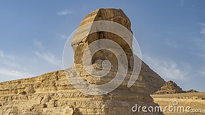 Sculpture of the great Sphinx against the blue sky and the pyramid of Menkaure Stock Photo