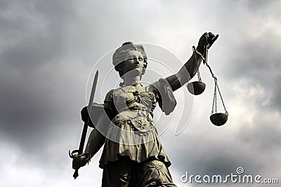 Sculpture of Justizia with dark clouds Stock Photo
