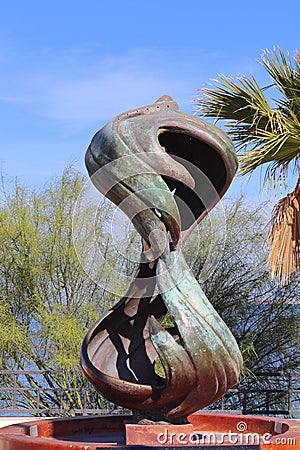 Sculpture in metal representing an hourglass. A time capsule is buried under the artwork Editorial Stock Photo