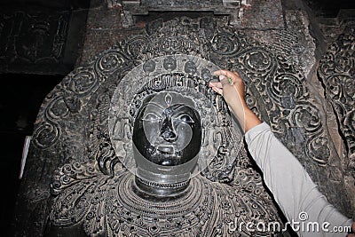 Sculpture with micro carved hallow skull at Hoysaleswara Temple Stock Photo