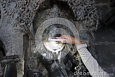 Sculpture with micro carved hallow skull at Hoysaleswara Temple Stock Photo