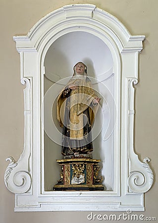 Sculpture of St. Teresa of Avila in a niche on a side wall of the Church of St. Mary of Graces in Varenna, Italy. Editorial Stock Photo