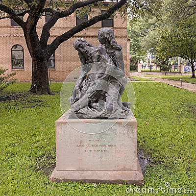 Sculpture with woman holding a sickly gaunt man on the grounds of the Holy Trinity Catholic Church in Dallas, Texas. Editorial Stock Photo