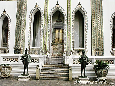 Sculptures of two mythological warriors guard the entrance of a building in the Royal Palace Stock Photo