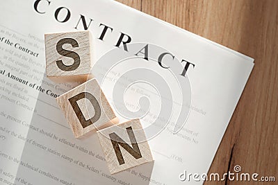 SDN acronym for SOFTWARE DEFINED NETWORKING written on wooden cubes lying on the contract on wooden table Stock Photo