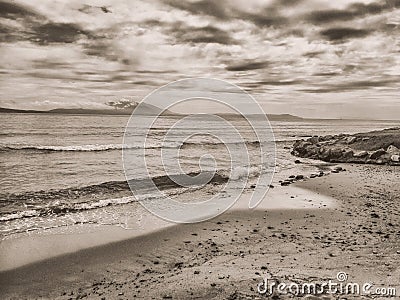 Sea wave on the sand beach with vignette, texture, bokeh, color and black and white effects. Stock Photo