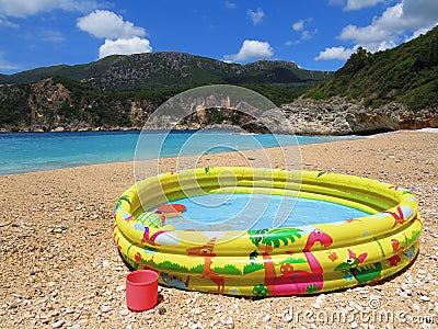 Sea blue waves and inflatable pool for kids in summer on the beach. Vacation and travel. Stock Photo