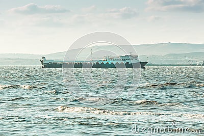 Sea cargo ferry. Mountanious background. Stock Photo