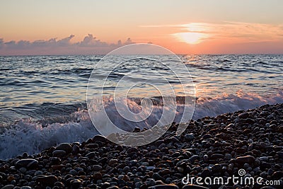 Sea coast with waves on sunset, Stony beach Stock Photo