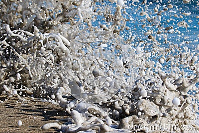 Sea foam created by waves surging on sand and creating amazing texture and patterns. Stock Photo