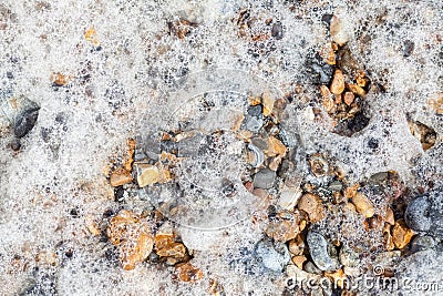 Sea foam over pebbles. Nature background image of seawater spume Stock Photo