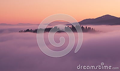 Sea fog in the pink light is very beautiful and fabulous, picturesque vague wave rolled on the slopes of the peaks Stock Photo