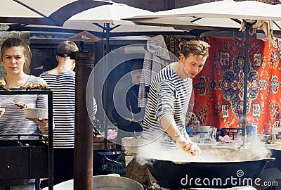 Sea-food cook preparing food in huge pan at outdoor party Editorial Stock Photo