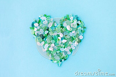 sea glass pieces in the shape of a heart on blue background Stock Photo