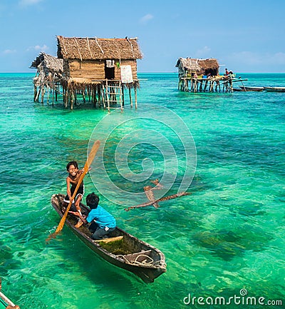 Sea Gypsy Kids on their sampan at their house on stilts Editorial Stock Photo