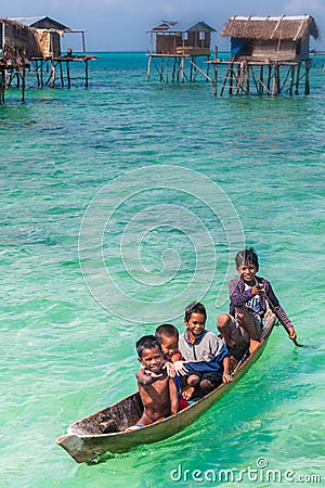 Sea Gypsy Kids on their sampan with their house on stilts in the Editorial Stock Photo