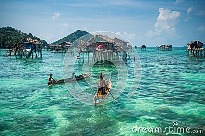 Sea Gypsy Kids on their sampan with their house on stilts in the Editorial Stock Photo