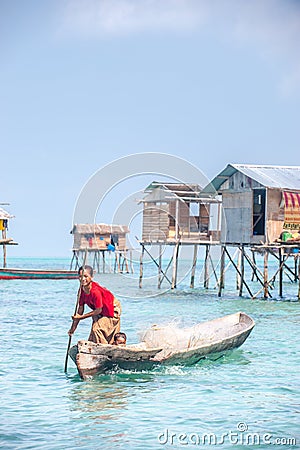 Sea Gypsy Woman paddling her sampan with her kids. Editorial Stock Photo