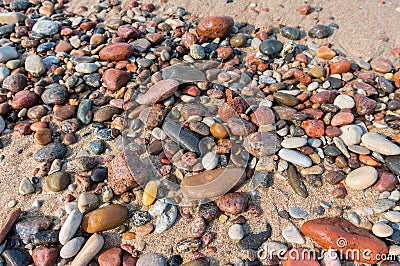 Sea pebbles on the sand, small smooth stones, stony seashore Stock Photo