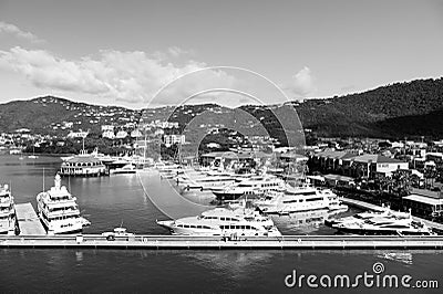 Sea port and town on sunny blue sky. Yachts moored at sea pier on mountain landscape. Luxury travel on boat, water Editorial Stock Photo