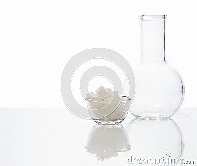 Sea Salt in glass container place next to Flat Bottom Flask. Side View Stock Photo