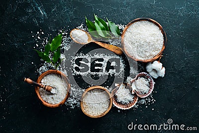 Sea salt with the inscription SEA. On a black stone background. Spa treatments. Top view. Stock Photo