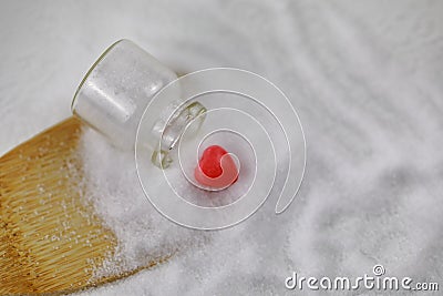 Grains of Natural Sea salt from a Upside down Glass bottle with red love Stock Photo