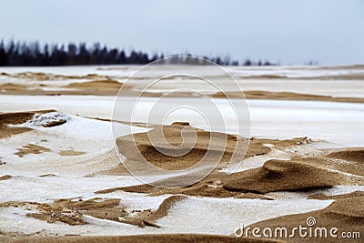 Sea sand with white snow, gray sky Stock Photo