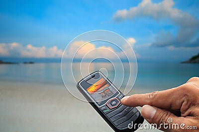 Sea scene in mobile phone and finger press o.k. Stock Photo