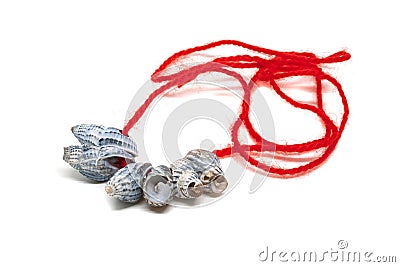 Sea shells on a red thread isolated on a white background. A handmade gift from the beach. Collecting seashells on vacation Stock Photo