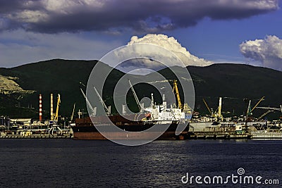 Sea ship, port crane and the mountains. Stock Photo