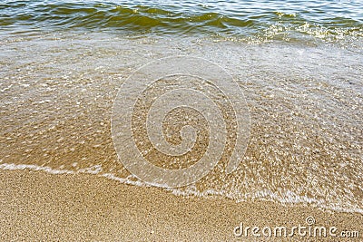 Sea shoreline with waves, sandy beach on a clear sunny day, close-up nature abstract background Stock Photo