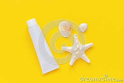 Sea starfish, seashells and white tube of sunscreen on yellow paper background. Mock up Template for lettering, text or your Stock Photo