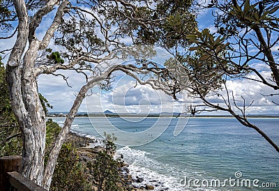 Sea surrounded by greenery under a blue cloudy sky in Noosa National Park, Queensland, Australia Stock Photo