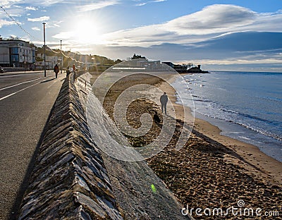 Sea Wall at sunrise, people and dogs walking Editorial Stock Photo