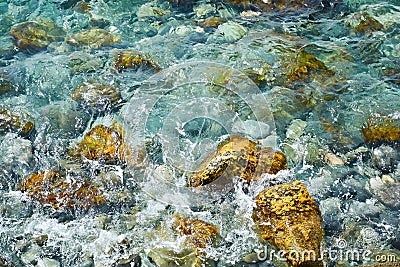 Sea water background of aquamarine color with stones, seashore. Wallpaper Stock Photo