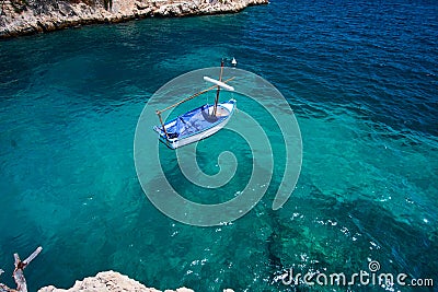 Sea water and granite stones. Boats above coral reef. Spain. Stock Photo