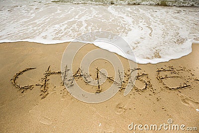 Sea wave with change texts on the sand Stock Photo