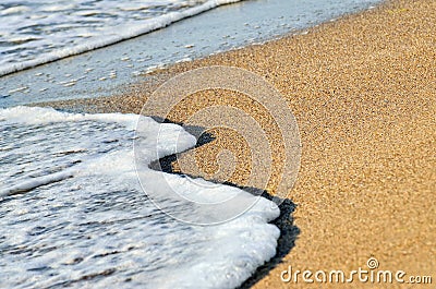 Sea Wave washes sand on the beach Stock Photo