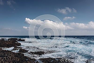 Sea waves crash on the rough rocky shore Stock Photo