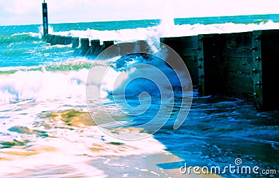 Sea waves crashing against a barrier Stock Photo