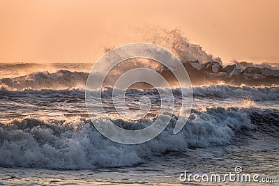 Sea waves crashing on a rocky pier in Marina di Massa, color version Stock Photo