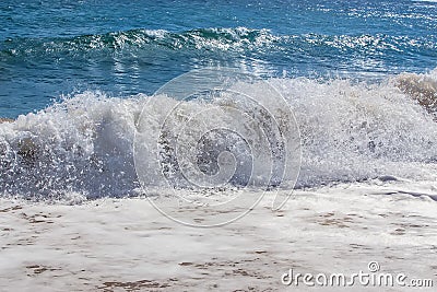 Sea waves roll on to shore with foam and sea spray. Stock Photo