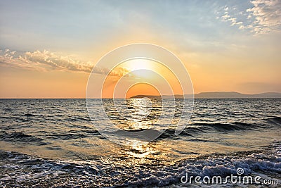 Sea waves and sunset sea in different tones in the sky Stock Photo