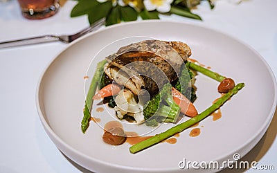 Seabass on a plate during Romantic dinner on beach of Huahin Thailand, Stock Photo