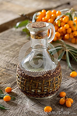 Seabuckthorn berries branch of sea buckthorn and oil on a vintage wooden background Stock Photo