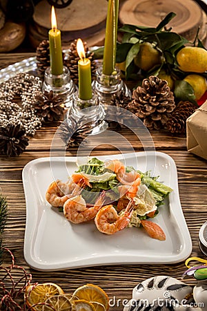 Seafood Green Salad with Salmon, Avocado and Shrimps on white plate on christmas decorated background Stock Photo